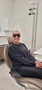 Hammasvahdin asiakas Mira Huttunen hymyilee leveästi hammaslääkärin tuolissa.